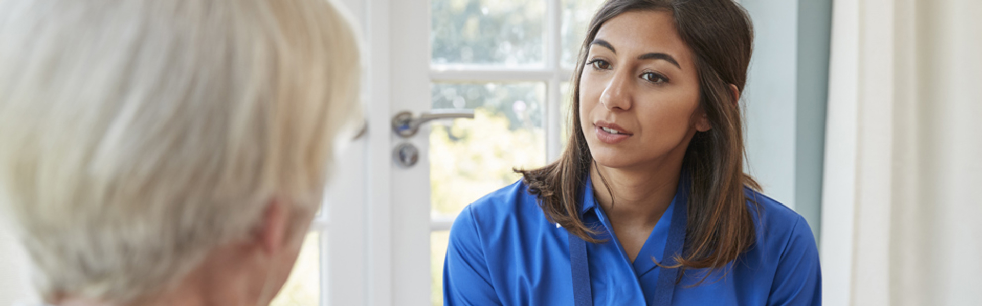 Female care worker explaining something to elderly lady