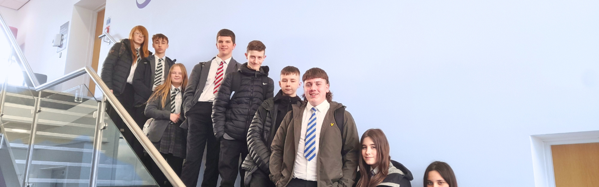 Group of nine school students of mixed genders stood on Learning Curve Group staircase