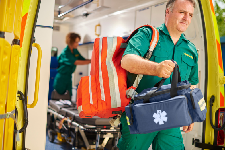 paramedic leaving ambulance with bags